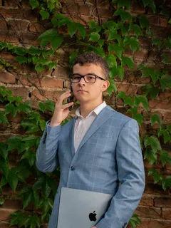 Dorian Drgonec v obleku telefonuje a drží MacBook, jako úplně normální seriózní CEO